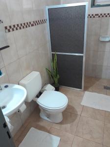 Un baño con inodoro, lavabo y ducha. en Departamento Itaembe Guazu, en Villa Dolores