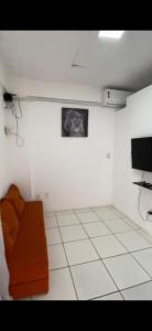 a room with a couch and a tv in it at AP térreo Ilhéus in Ilhéus