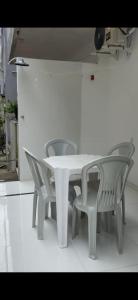 a table with two chairs and a white table and chairs at AP térreo Ilhéus in Ilhéus