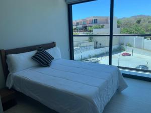 ein Bett in einem Schlafzimmer mit einem großen Fenster in der Unterkunft Park Life Narval in Bucerías + 28 Fotos