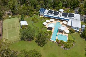an aerial view of a house with a tennis court at Beach Road Holiday Homes in Noosa North Shore