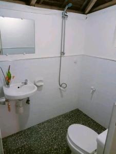 a white bathroom with a toilet and a sink at Balai Ko Beach & Cottages in El Nido