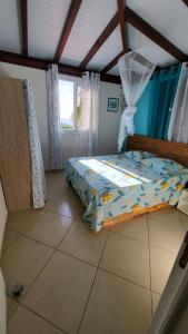 a bedroom with a bed in a room at Villa MIELéCAJOU, entre mer et montagne in Deshaies