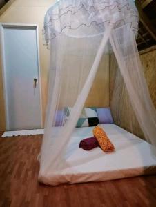 ein kleines Bett mit Baldachin in einem Zimmer in der Unterkunft Balai Ko Beach & Cottages in El Nido