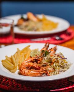two plates of food with shrimp and french fries on a table at C Beyond Nilaveli in Nilaveli