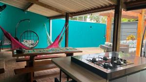 a living room with a stove and a hammock at Casa do Centrinho BonitoMS in Bonito