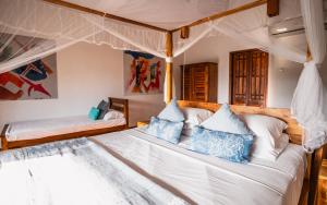 a bedroom with two beds with blue and white pillows at C Beyond Nilaveli in Nilaveli