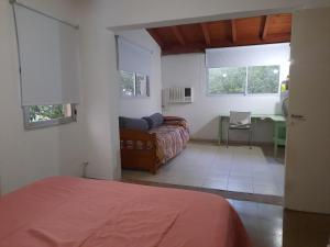 ein Schlafzimmer mit einem Bett und einem Schreibtisch in einem Zimmer in der Unterkunft Departamento amplio y equipado en Santiago del Estero in Santiago del Estero