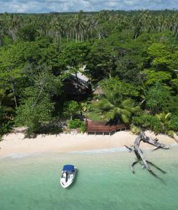 Entire Beach Front Resort Home - Tides Reach Beach House في Saraotou: اطلالة جوية على قارب على شاطئ