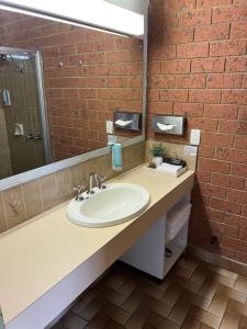 a bathroom with a sink and a mirror at Alexandra Motor Inn - Victoria Aus in Alexandra