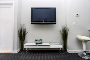 a living room with a tv on a white wall at Stylish Studio on Newbury St #3 in Boston