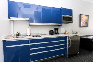 Stylish Studio on Newbury St #3 في بوسطن: مطبخ مع دواليب زرقاء ومغسلة