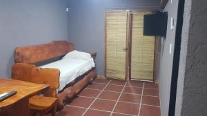 Dormitorio pequeño con cama, mesa y sidra de mesa en Alojamiento Tanti en Villa Santa Cruz del Lago