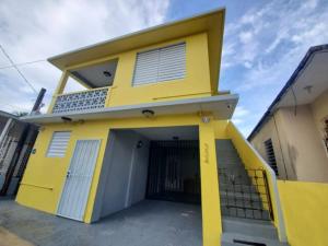 una casa amarilla con garaje en Laguna Spacious Private Studio near Beach and famous Restaurants, Unit 2, en San Juan