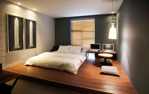 um quarto com uma cama e uma secretária com 2 monitores em Brown Dot Hotel GimhaeEobang em Gimhae