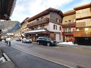 a street with cars parked in front of a building at La Ruche RU0490 in La Clusaz