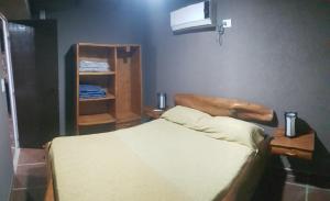 1 dormitorio con 1 cama y TV en la pared en Alojamiento Tanti en Villa Santa Cruz del Lago