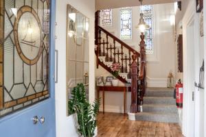 a hallway with a staircase with stained glass windows at The New England in Eastbourne