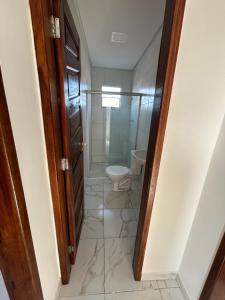 a bathroom with a toilet and a walk in shower at Casa união in Olinda
