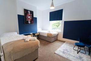 a bedroom with a bed and a couch and a window at Teal Retreat - Central Location - Free Parking, FastWifi, SmartTV with Netflix by Yoko Property in Redcar