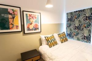 a bedroom with a bed and two pictures on the wall at Teal Retreat - Central Location - Free Parking, FastWifi, SmartTV with Netflix by Yoko Property in Redcar