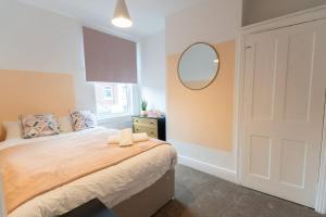 a bedroom with a bed with a mirror and a door at Teal Retreat - Central Location - Free Parking, FastWifi, SmartTV with Netflix by Yoko Property in Redcar