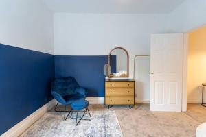 a blue room with a chair and a mirror at Teal Retreat - Central Location - Free Parking, FastWifi, SmartTV with Netflix by Yoko Property in Redcar