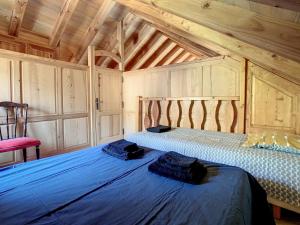 2 camas en una habitación con techos de madera en Gîte authentique -Mont Lozère, en Les Bondons