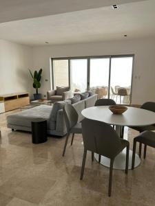 Una sala de estar con un sofá, una mesa y sillas. en 2BR Apartment with Beach Club, en Cancún 37 fotos más