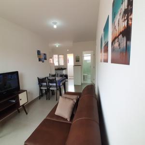 un soggiorno con divano marrone e TV di AP Bertioga - Praia Indaia - Wi-Fi 500 Mega a Bertioga