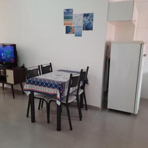 a table and chairs in a room with a television at AP Bertioga - Praia Indaia - Wi-Fi 500 Mega in Bertioga