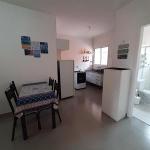 a kitchen with two chairs and a table and a refrigerator at AP Bertioga - Praia Indaia - Wi-Fi 500 Mega in Bertioga