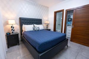 サンティアゴ・デ・ロス・カバリェロスにあるSoha Suites Santiago Gem Rare Findのベッドルーム1室(ベッド1台、ランプ2つ、クローゼット付)