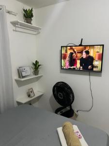 a tv hanging on a wall in a room at Quarto Encantado in João Pessoa