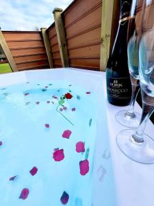 una mesa con dos copas y una botella de vino en Oak Lodge 7 Hot Tub, en York