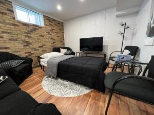 a living room with a bed and a brick wall at Bertha's charming urban retreat in Laval