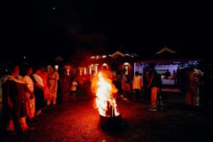 Meenangadi的住宿－The River Mist，一群人晚上站在火炉旁