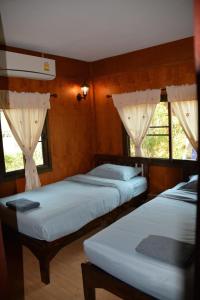una camera con tre letti e due finestre di Cozy stay in old town a Chiang Mai