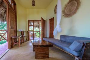 a living room with a blue couch and a table at Hotel Ruunda in San Agustinillo