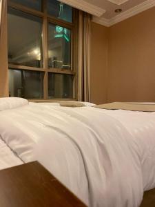 Ajyad的住宿－فندق لؤلؤة الصفا，窗户客房内的一张白色床