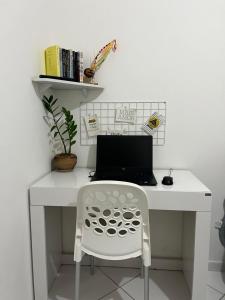 a white desk with a laptop and a chair at Quarto Encantado in João Pessoa
