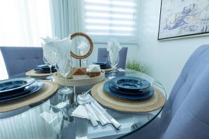 a glass table with plates and dishes on it at Soha Suites Santiago Gem Rare Find in Santiago de los Caballeros