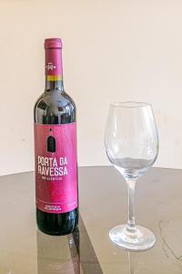 a bottle of wine next to a wine glass at Quarto próximo da Savassi. in Belo Horizonte