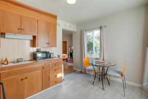 a kitchen with wooden cabinets and a table with chairs at Downtown Oakland Studio, 6 Mi to Toll Plaza Beach! in Oakland