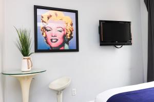 um quarto com uma televisão e uma fotografia na parede em Cozy & Stylish Newbury Street Studio, #9 em Boston