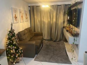 a living room with a christmas tree and a couch at Quarto Encantado in João Pessoa