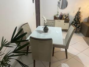 ein Esszimmer mit einem weißen Tisch und Stühlen in der Unterkunft Quarto Encantado in João Pessoa