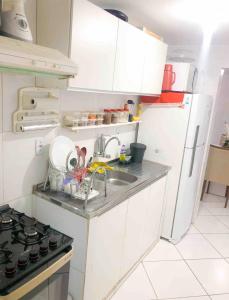 a small kitchen with a sink and a refrigerator at Quarto Encantado in João Pessoa