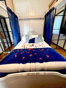 uma cama com um edredão azul com flores em Holly Lodge 12 Hot Tub em York