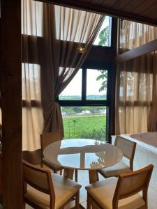 uma sala de jantar com uma mesa e cadeiras e uma janela em Refúgio vila das figueiras ! em Torres